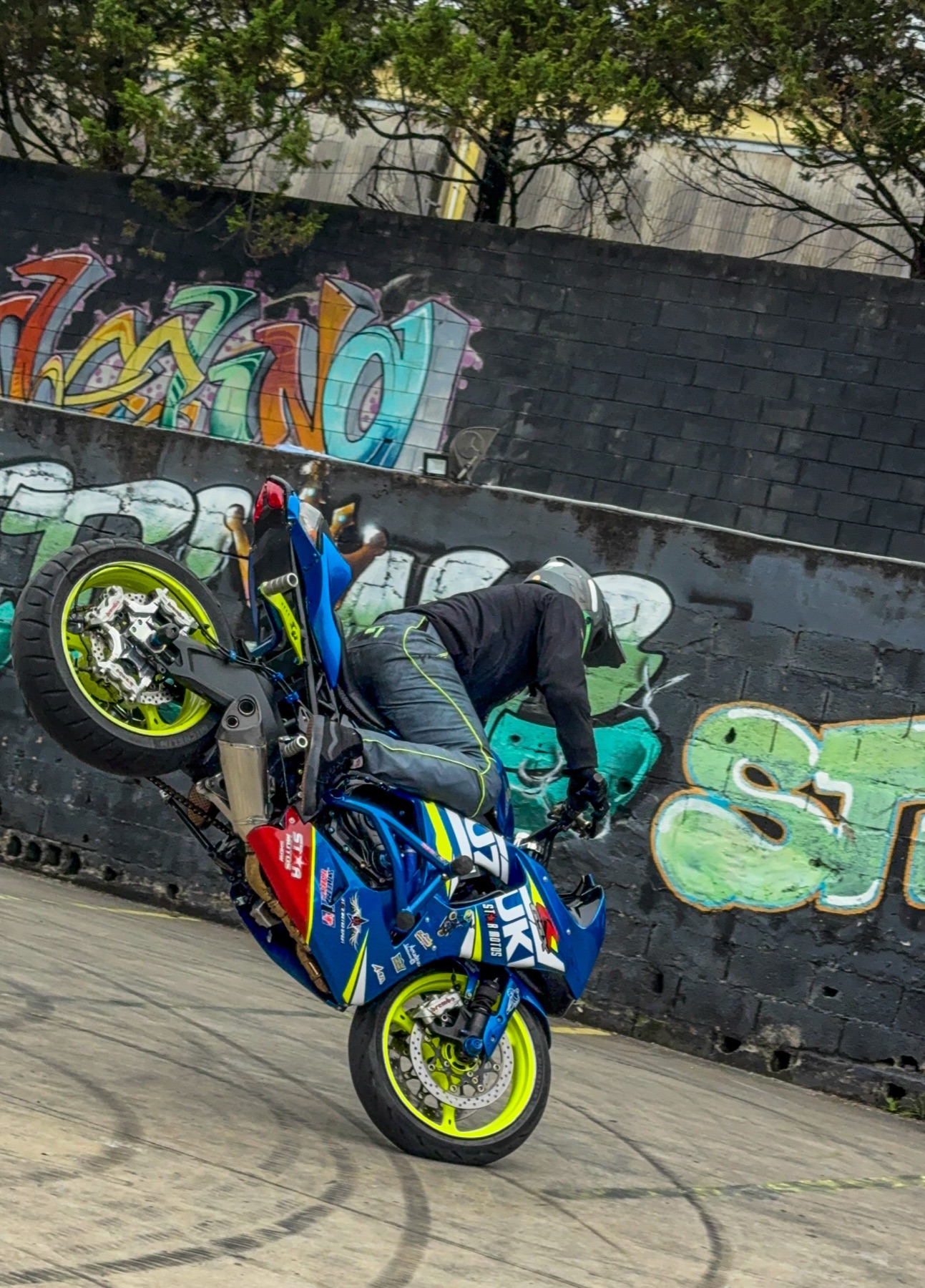 Wheeling em frente a um muro grafitado