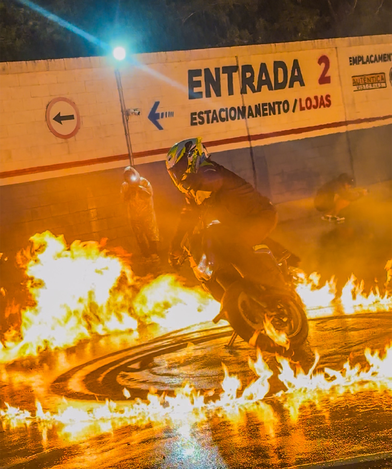 Darlan cruza um corredor de fogo em um evento noturno