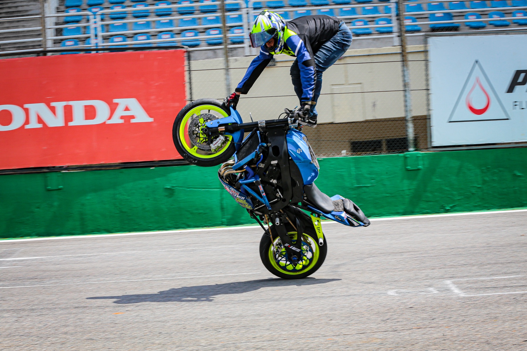 Darlan de pé sobre a moto em manobra no autódromo