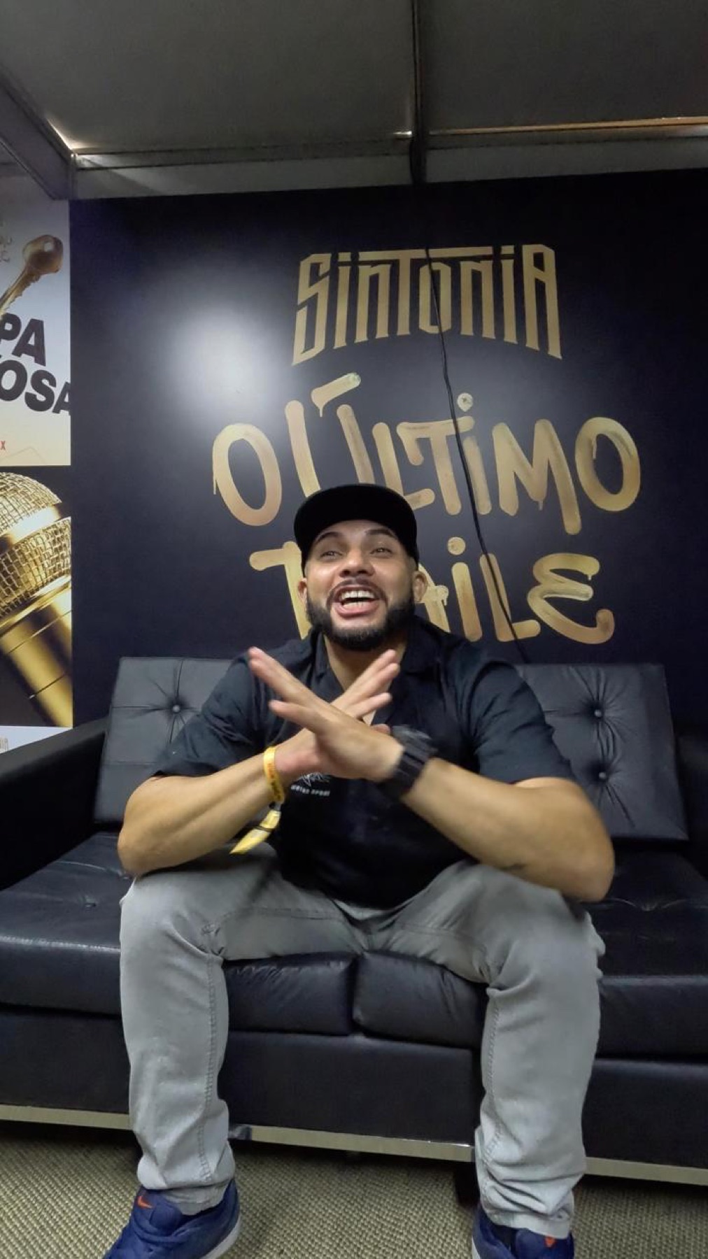 Darlan sentado em frente ao painel de Sintonia, O Último Baile