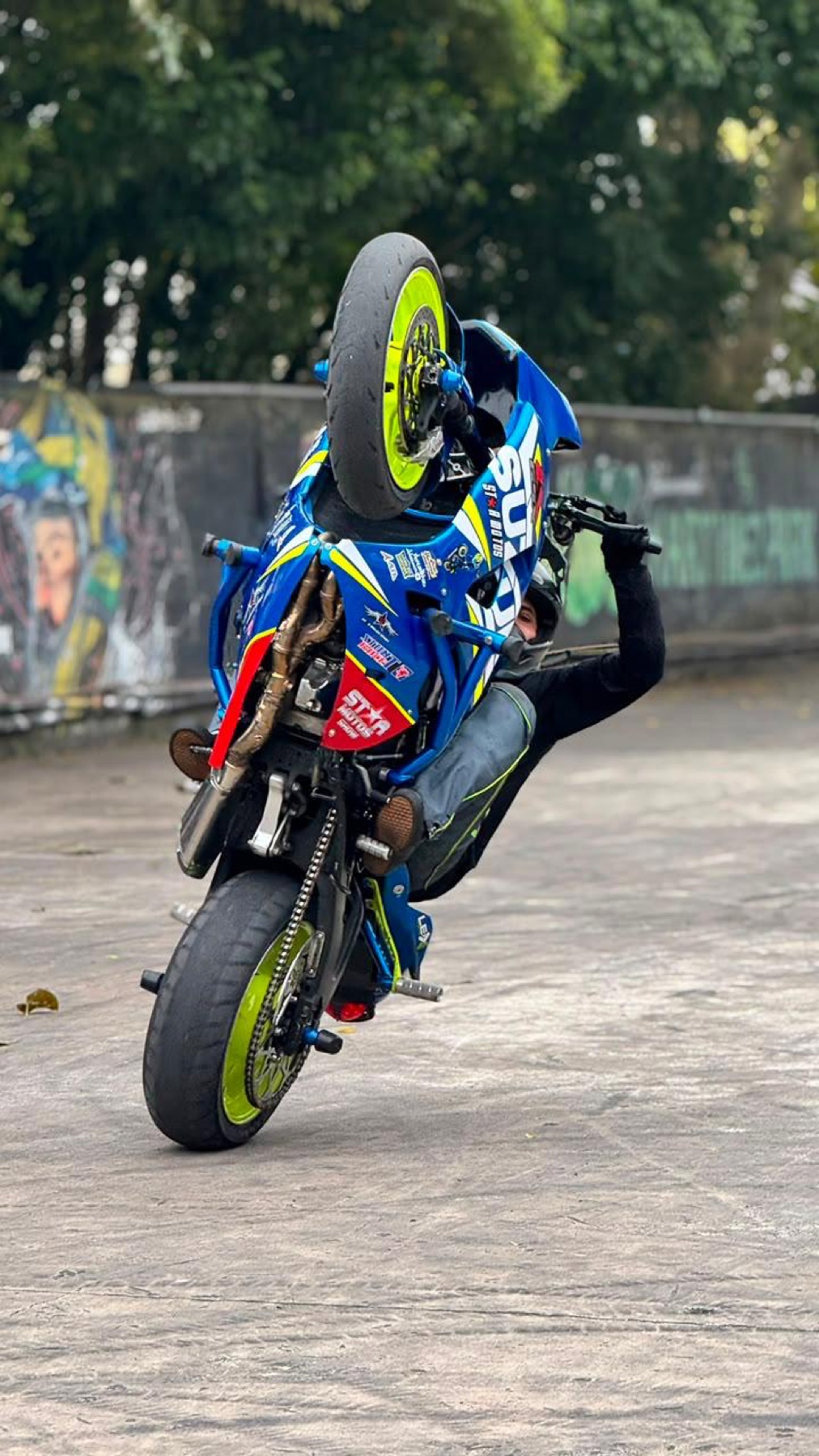 Wheeling quase vertical em frente ao muro grafitado