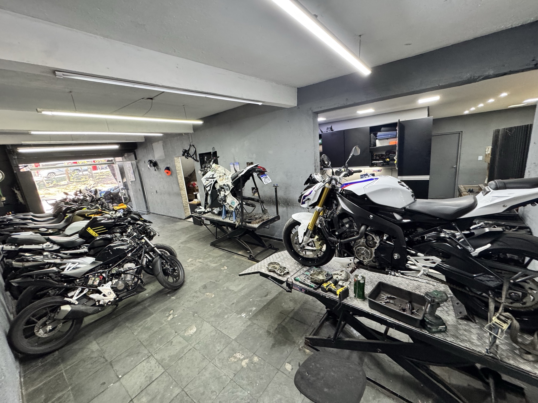 Interior da oficina com motos nos elevadores