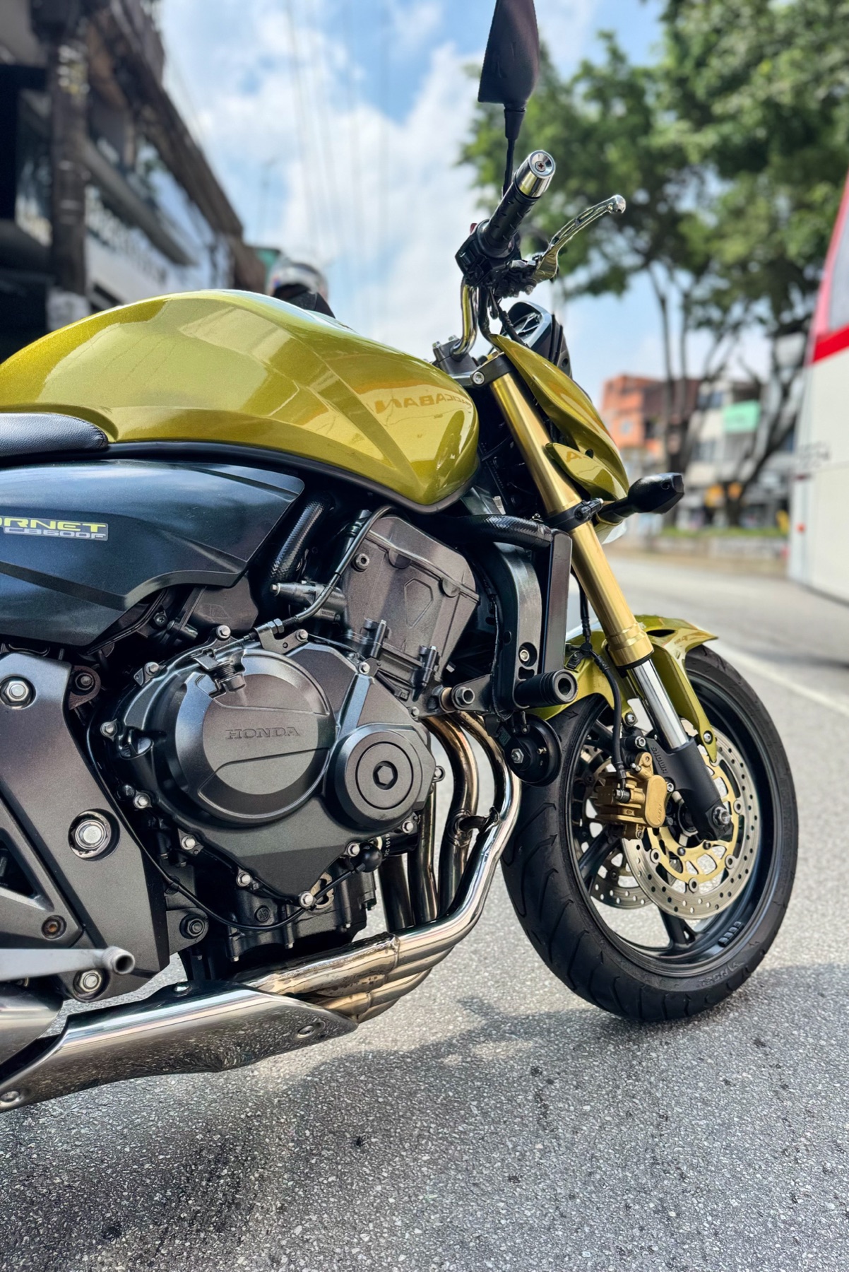 Honda Hornet dourada em frente à oficina